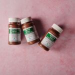 Een persoon die ontspant met een magnesiumsupplement, omgeven door natuur en rust, symboliseert herstel en welzijn.
