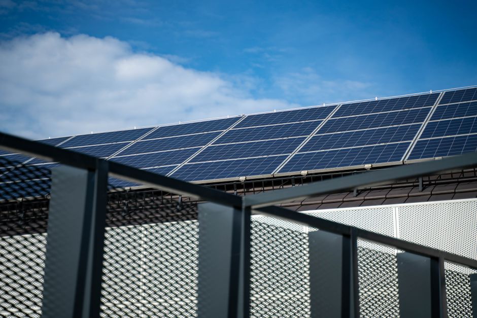Een zelfstandige ondernemer die zonnepanelen en een thuisbatterij installeert voor off-grid energieoplossingen.